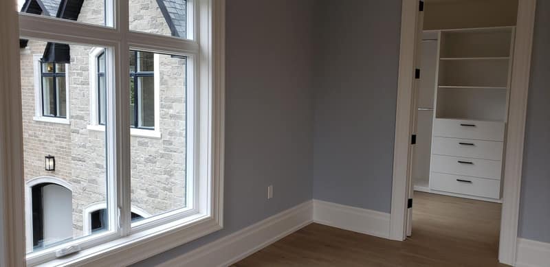 Bedroom opening into a built-in walk-in closet, with fresh paint and wide-plank floors